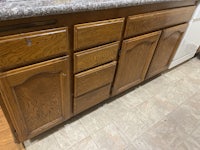 a kitchen with wooden cabinets and counter tops