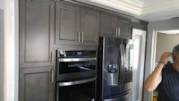 a man is taking a picture of a refrigerator in a kitchen